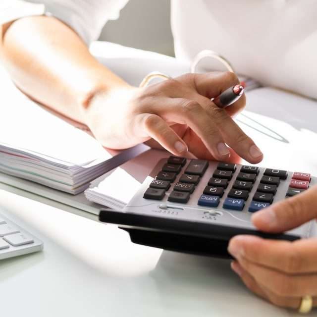 Lady Calculating Invoice. Chartered Accountant With Calculator